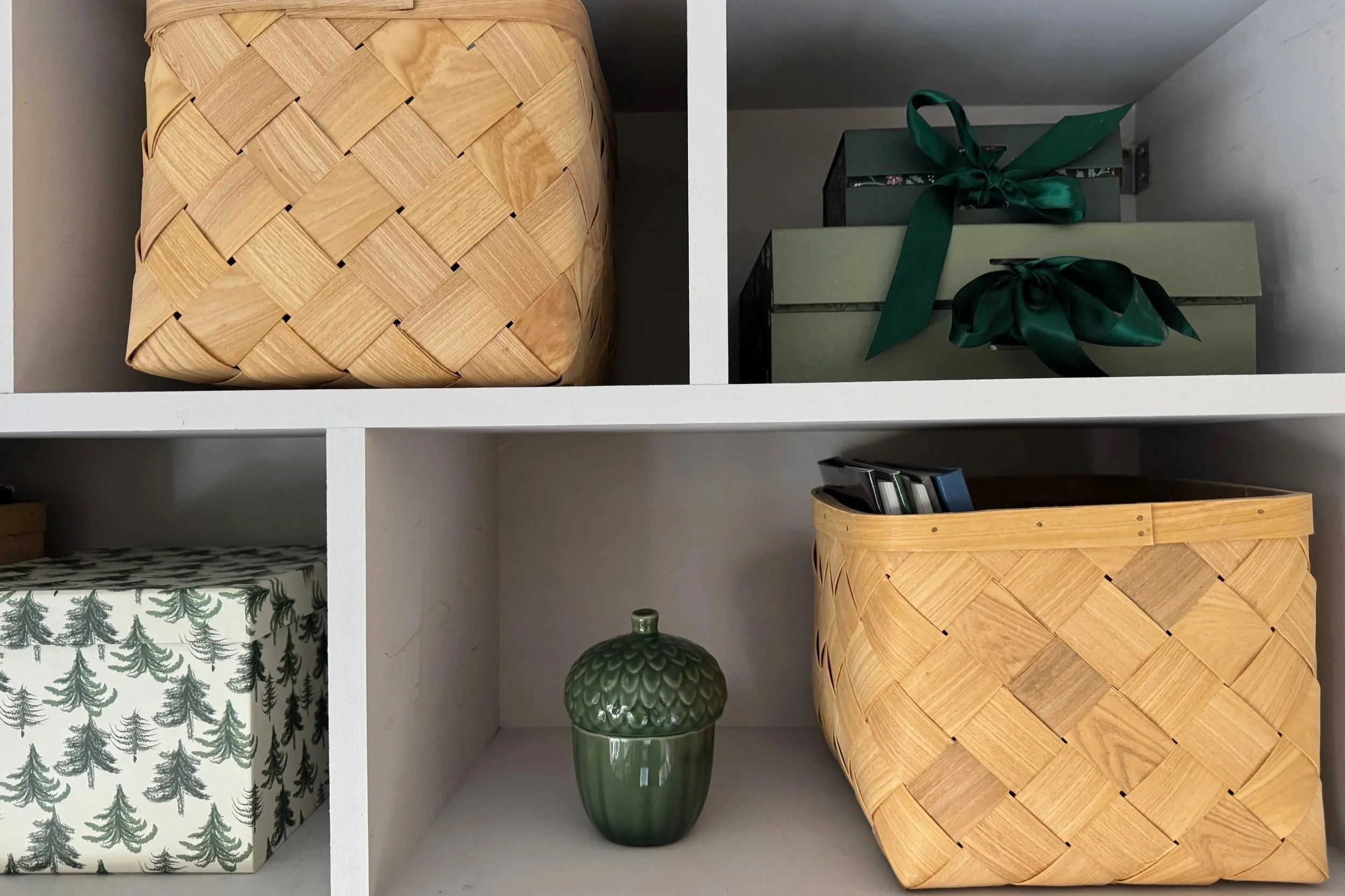 Close up of shelves with green, white and natural coloured boxes
