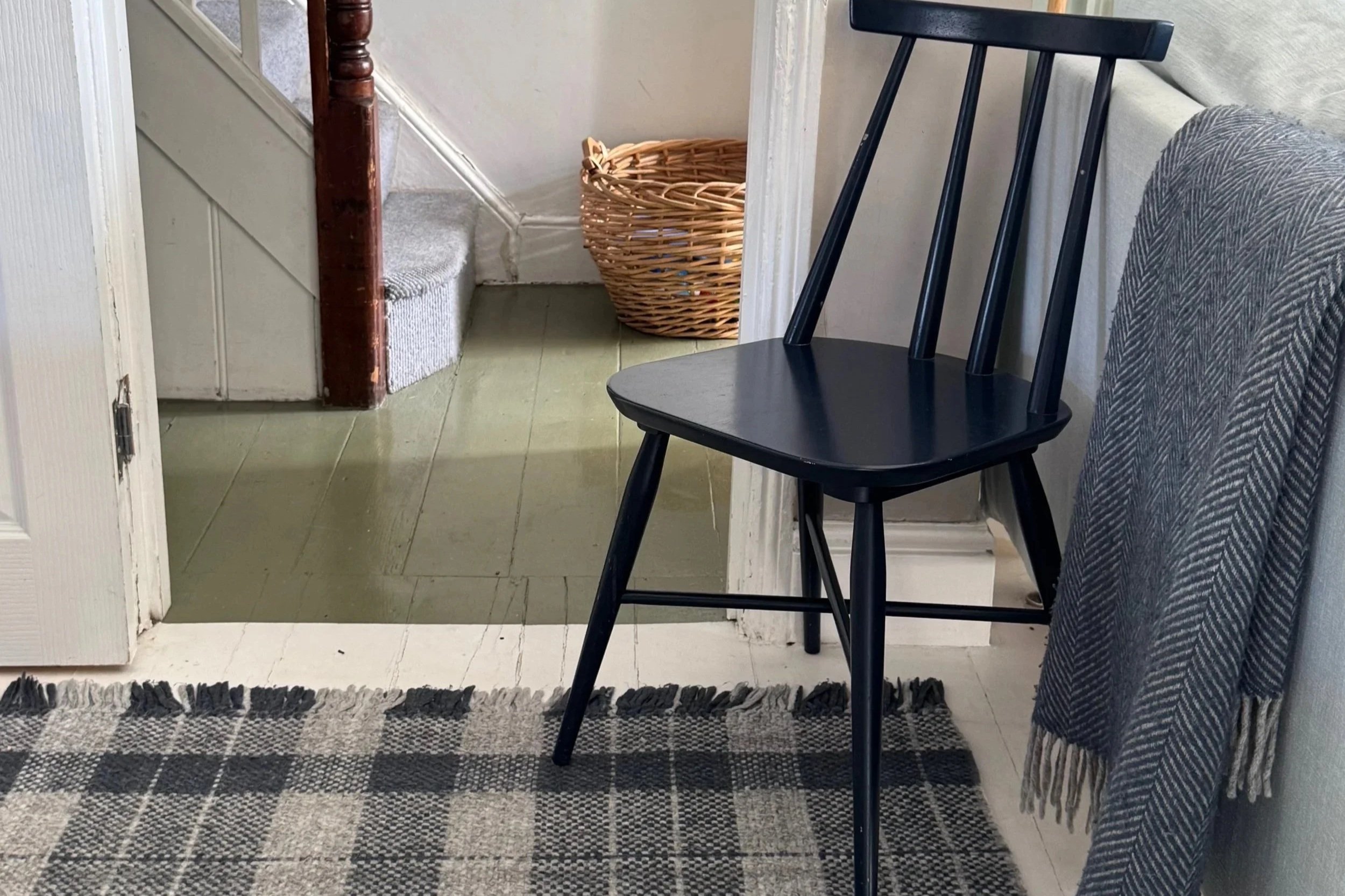 Navy blue dining chair on blue tartan rug looking into hall