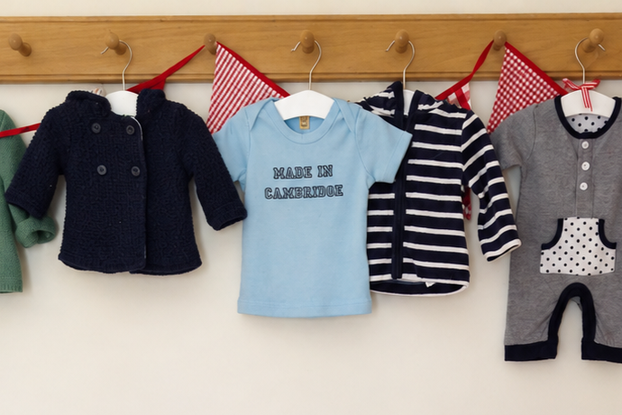 Peg rail with blue and white baby clothes hanging