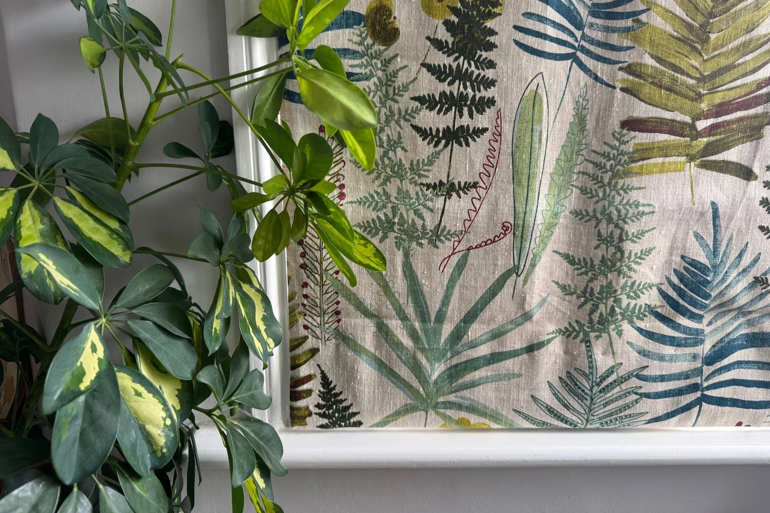 Close up of plant and fabric blind in botanical print