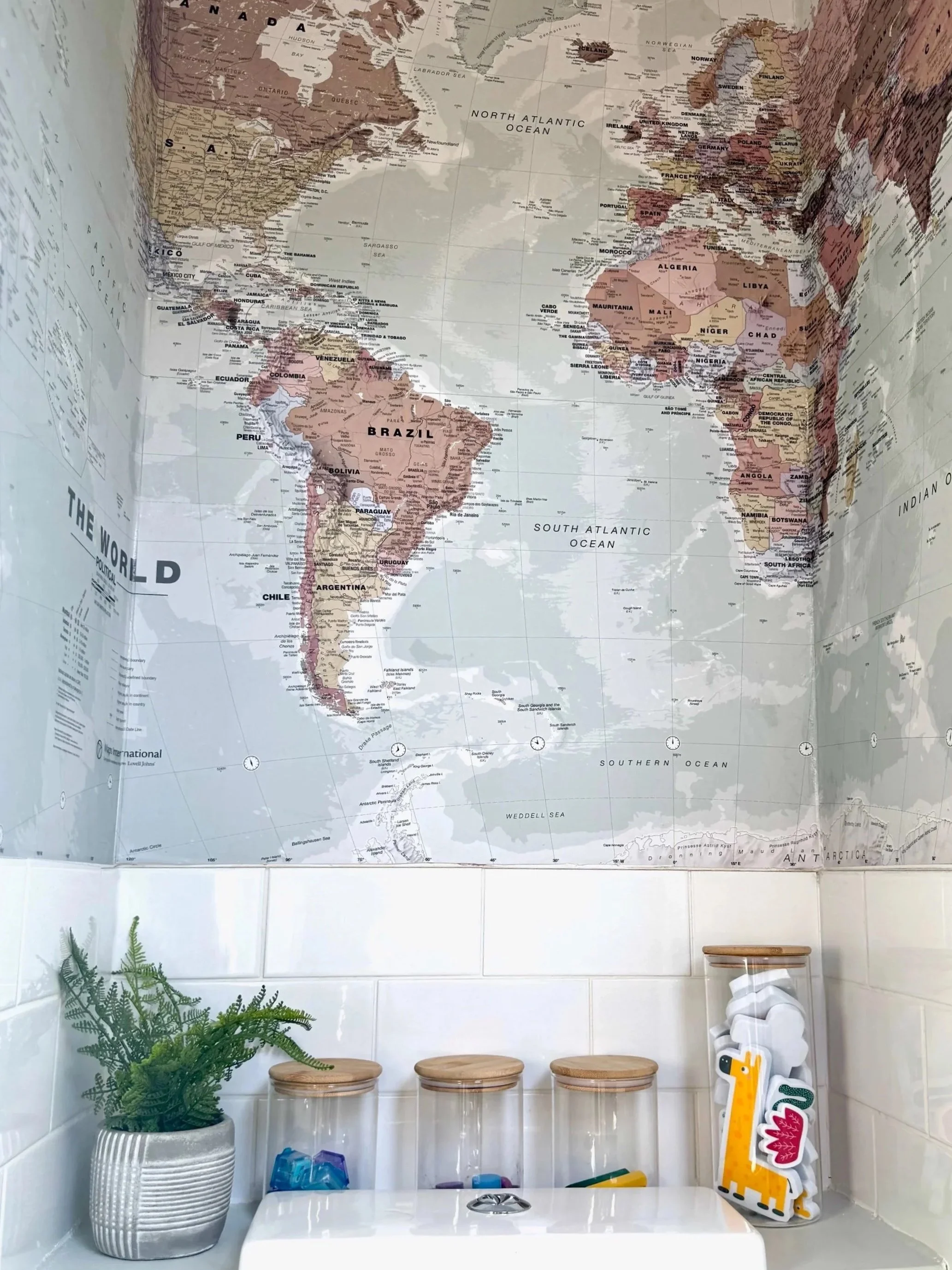 View of wall with large map papered onto wall over the toilet