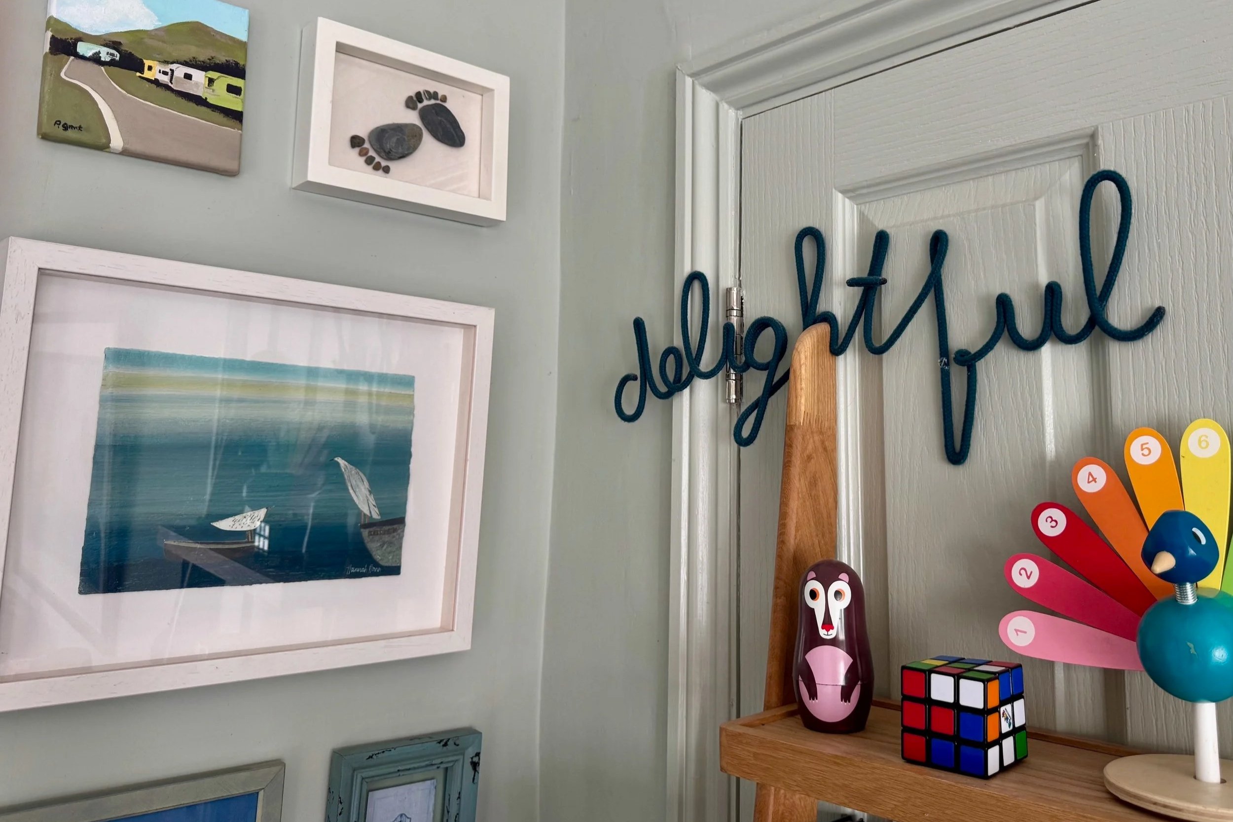 Group of pictures and book shelf with toys on
