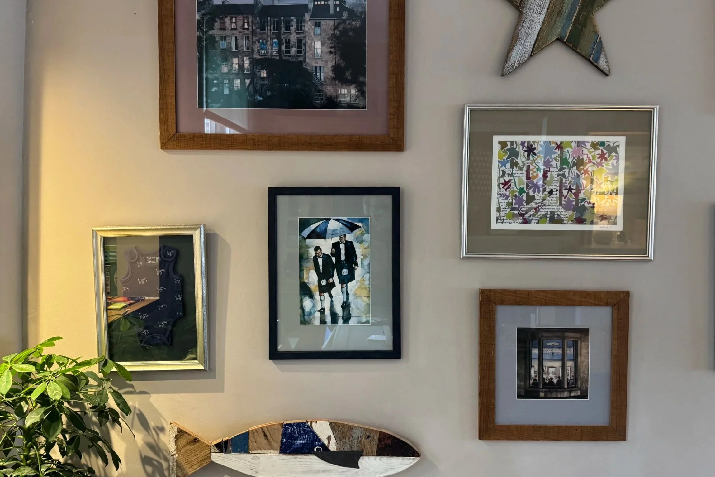 picture wall of paintings, prints and wooden fish wall art