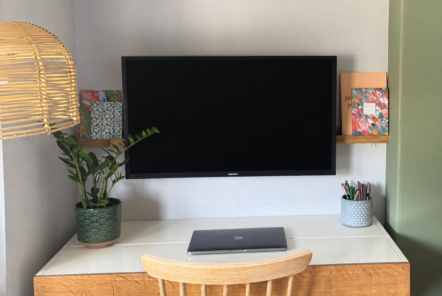 Wood and white desk with black screen and laptop on table top along with a small plant
