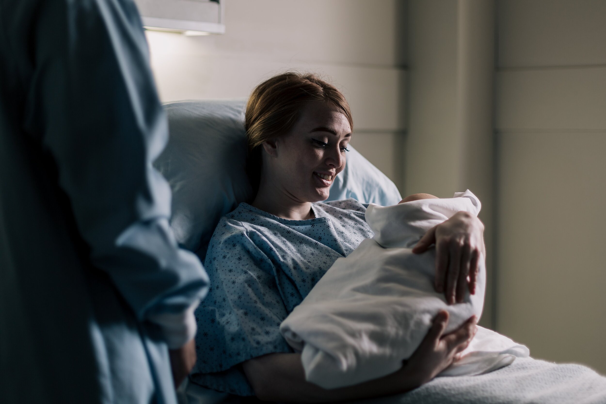 new-mother-smiling-at-her-baby-while-resting-in-hospital-bed.jpg