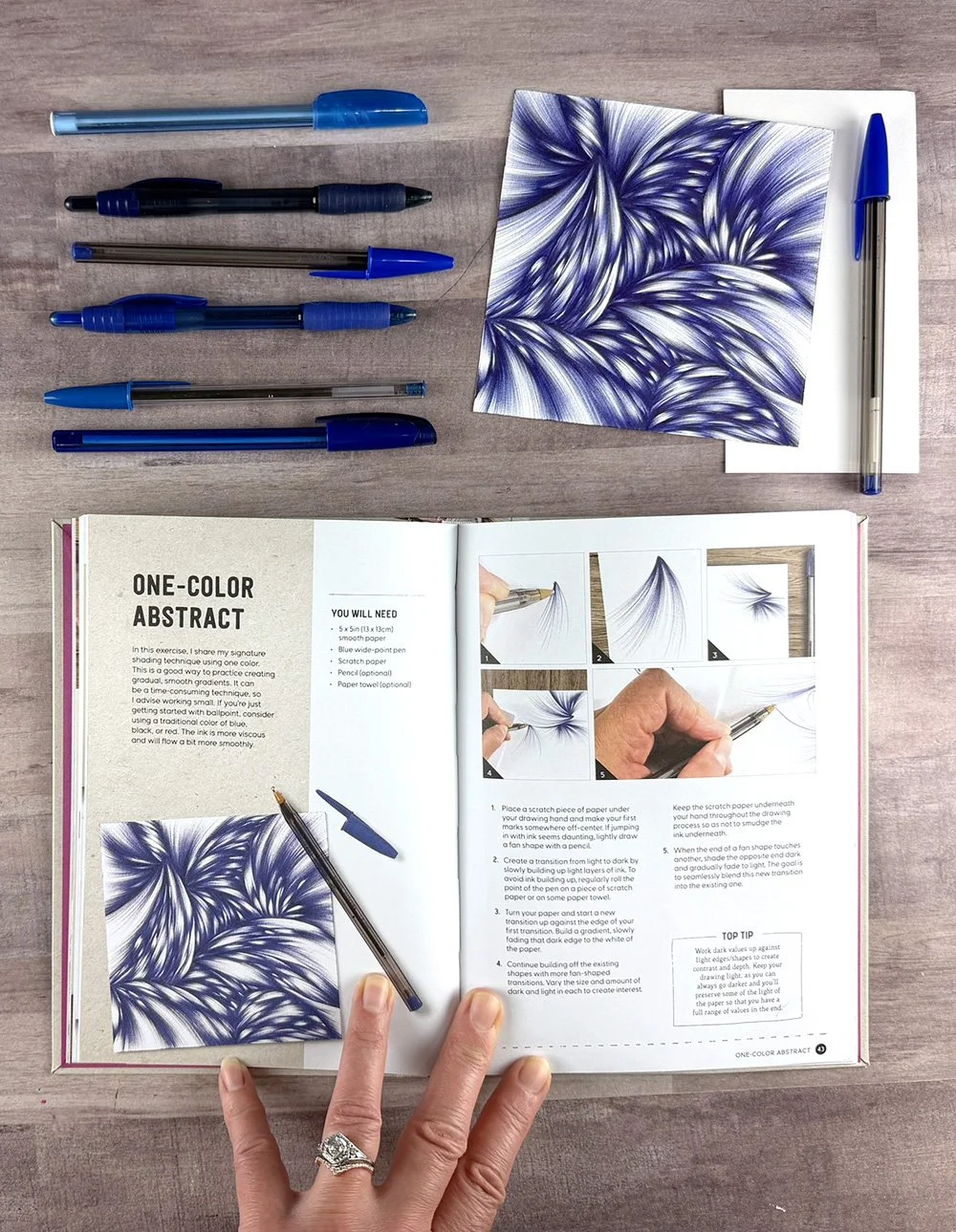 One-Color Abstract drawing along with several blue ballpoint pens and the corresponding project page in the Me & My Ballpoint Pen book.