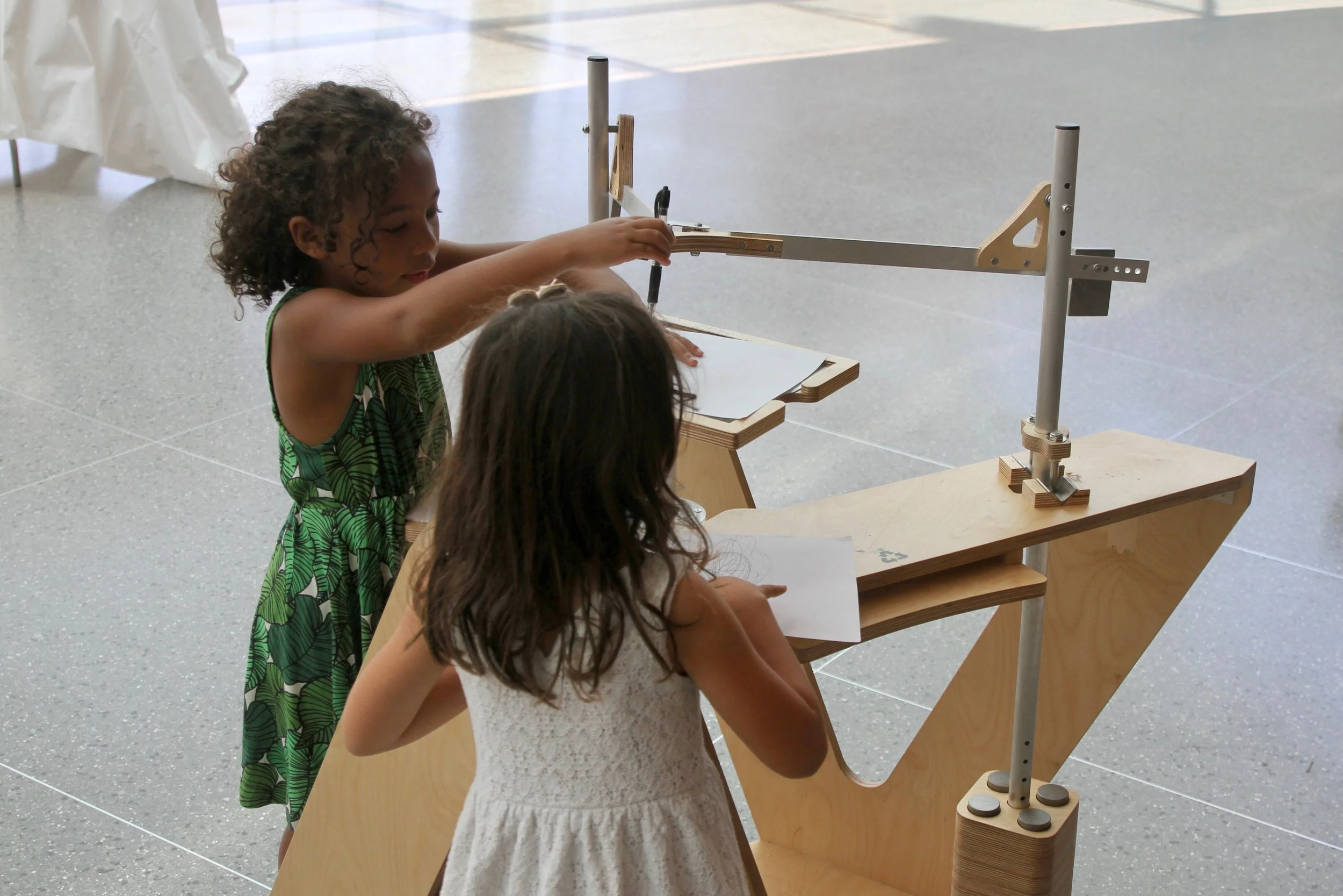 Children experiencing the harmonograph during its time in the foyer of the Brooklyn Museum.