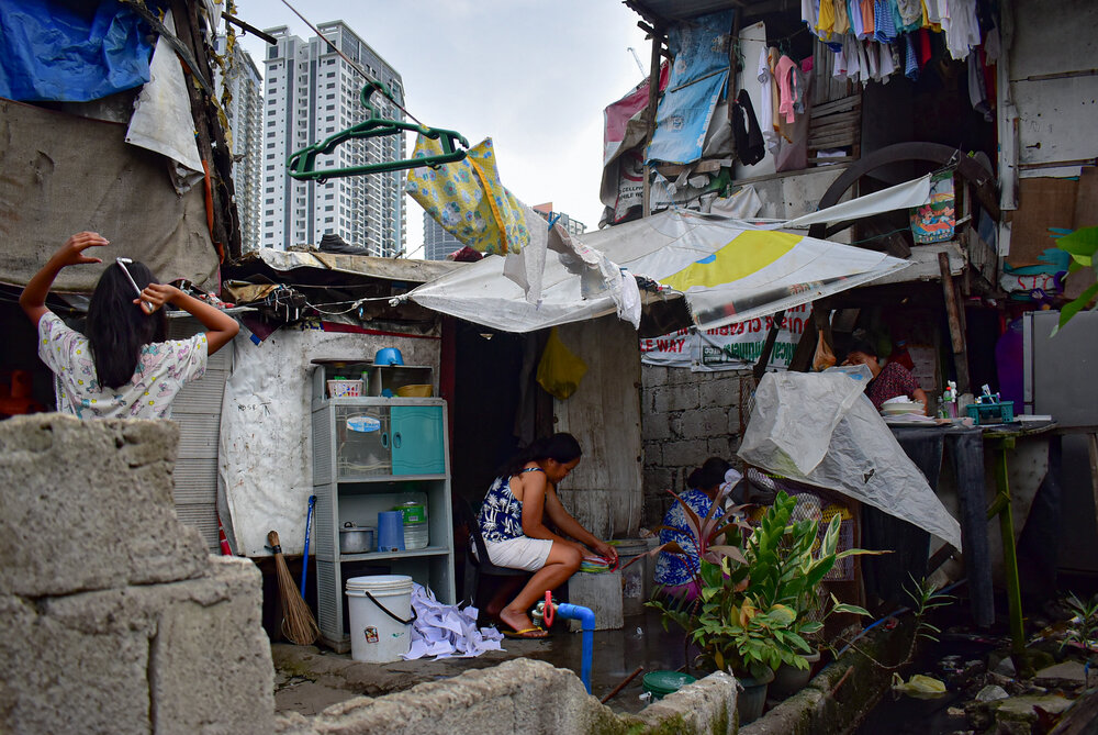  Line Nalangan makes rags and chats with neighbors as they help finish each other's chores. She needs to sell five bundles of rags a day to help cover her family’s expenses. 