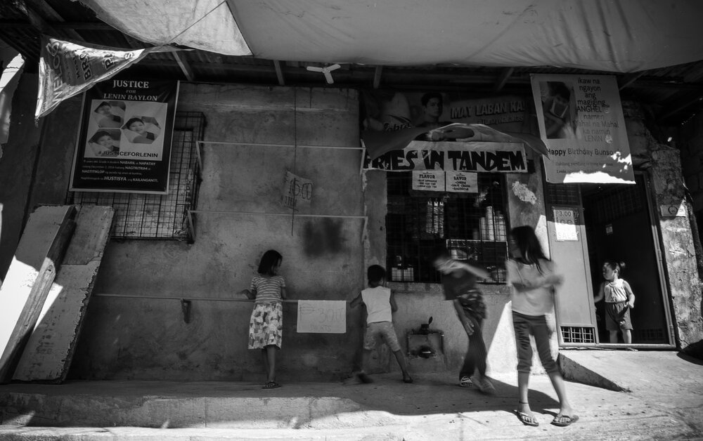   Children play on the street outside the Baylon family’s residence. Tarpaulins of drug war victim Lenin Baylon, who used to be their playmate, hang in front of the house.&nbsp;     Sweet and thoughtful. This is how Lenin Baylon, a casualty of the dr