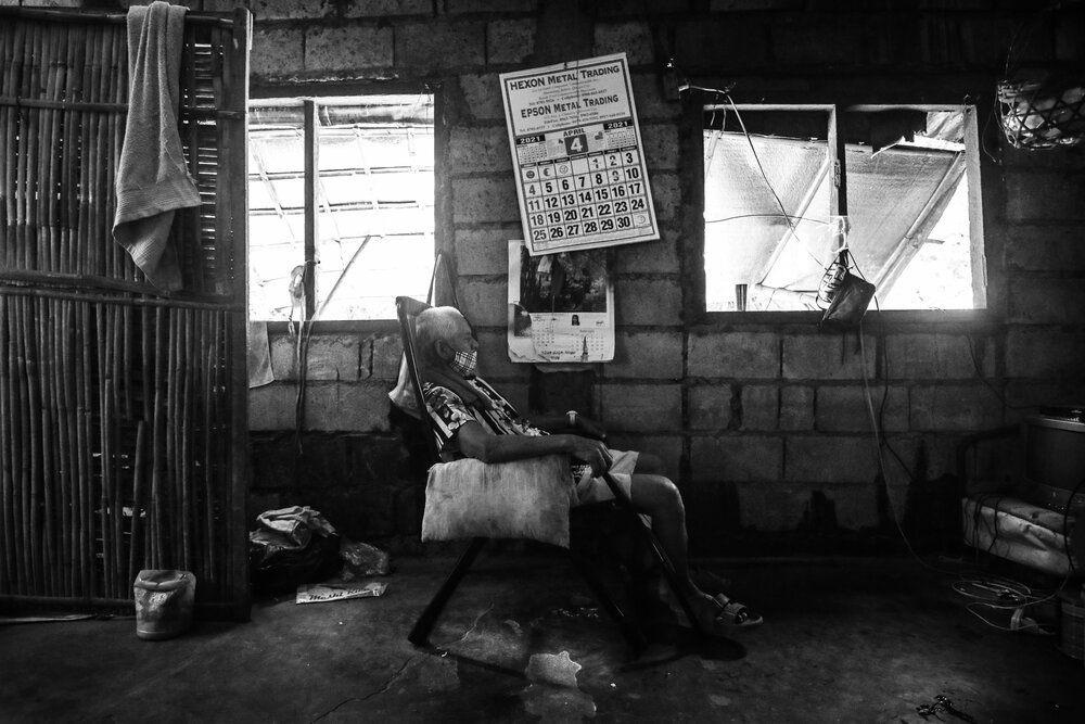   Julio Tejones, a widower, takes a nap in a chair, exhausted from his daily duties of collecting garbage, cleaning the barangay (village) hall and watching over his four grandchildren. He lost two sons, Jonie and Manuel, both victims of extrajudicia