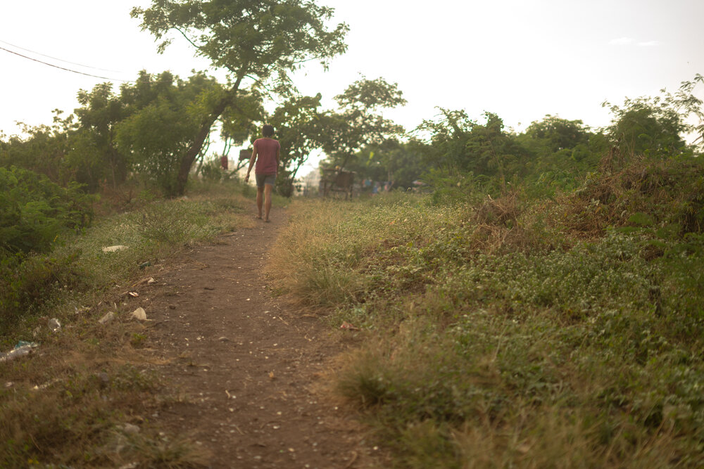  Amy makes her way to her home at Smokey Mountain, a former dumpsite in Manila, on April 9, 2021. When her sons left for foster care, Amy's neighbor offered her a room where she could live for free, in exchange for helping with household chores. 