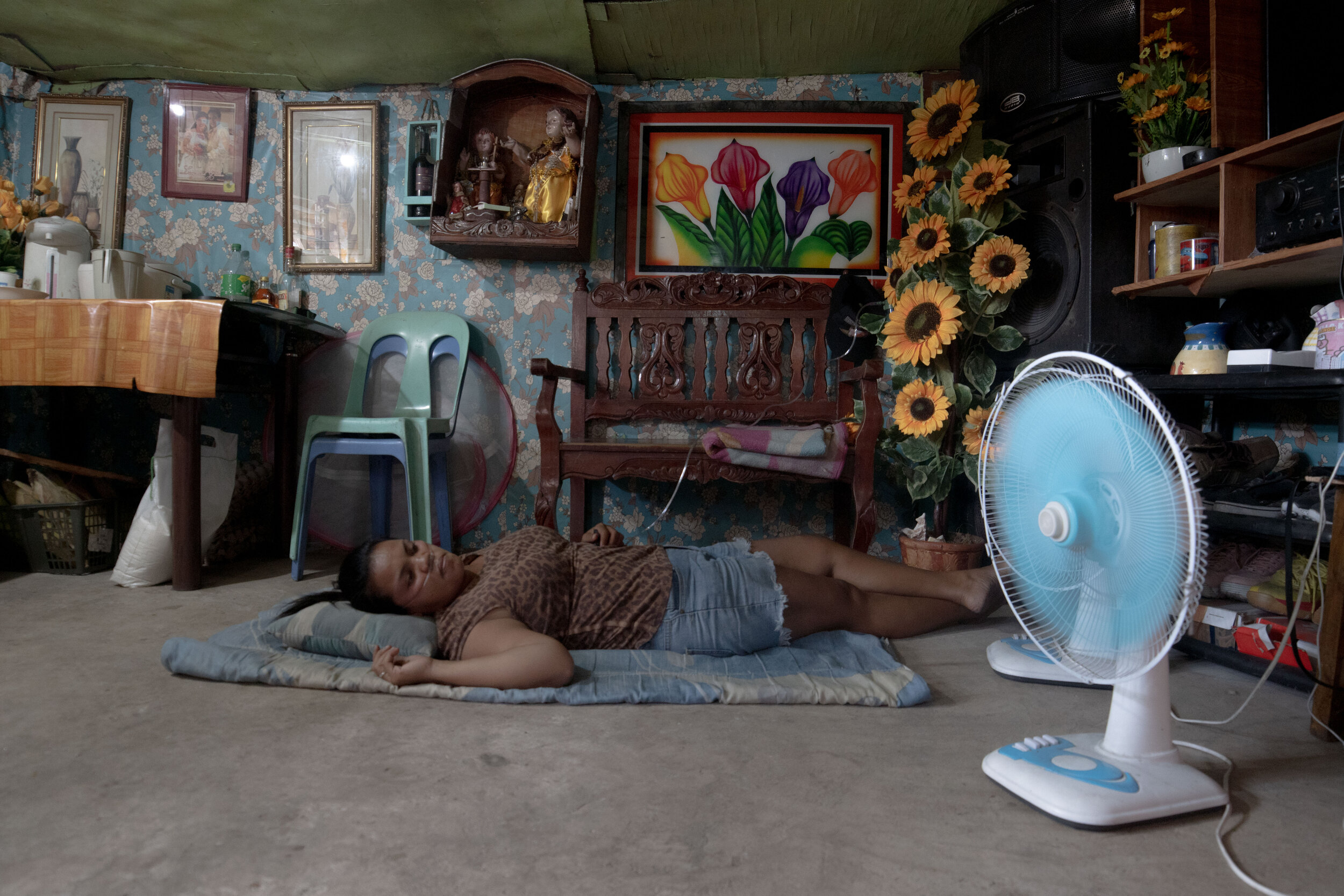  Due to her heart condition, Lucila Buladaco uses a portable oxygen cylinder at her home in Smokey Mountain, Manila on March 27, 2021. Her doctor discouraged her from performing strenuous activities. At home, her family, nephew, and nieces do most of