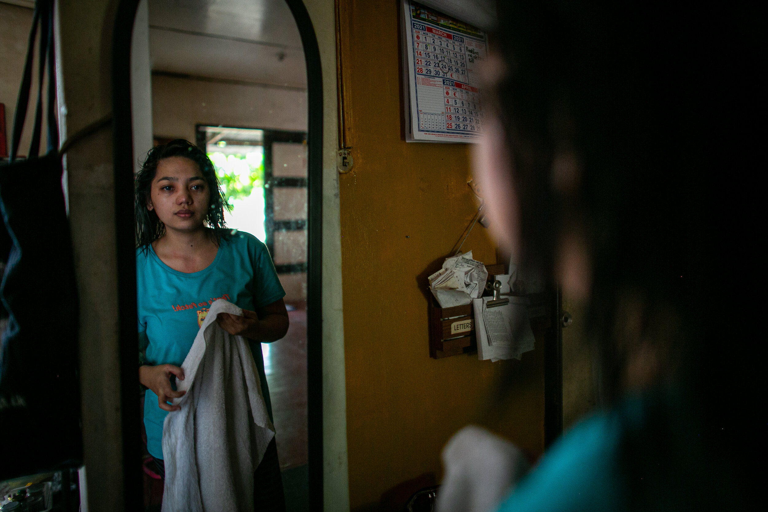  Jenny Beth Mariano, a 25-year-old youth church leader, looks in the mirror to examine if she’d put her contact lenses properly. Last year, Mariano was forced to cut her long hair, use contact lenses instead of eyeglasses, and dress differently to st