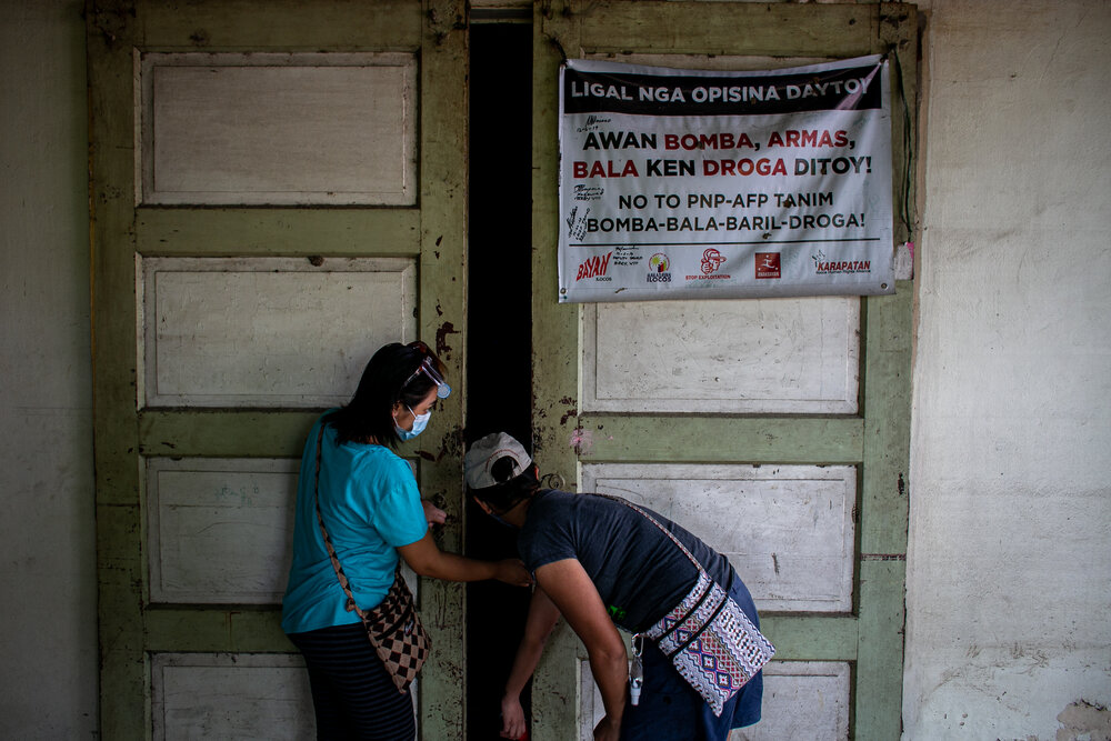  Jenny Beth Mariano and another youth activist close the door of the office of Ilocos Human Rights Alliance (IHRA). In 2019, IHRA voluntarily subjected its office to an ocular inspection to prove that there were no guns and explosives inside the buil