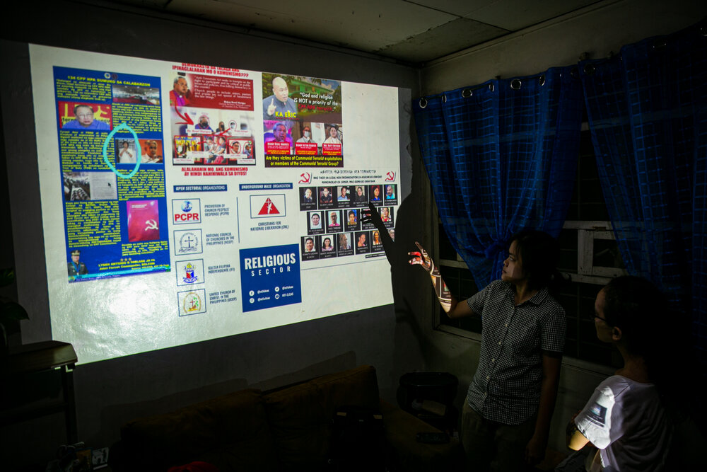  Screen shots of anti-communist materials posted in different social media platforms by the state security forces are projected on a wall during a discussion on red-tagging by some members of the media and church groups. The materials showed names an