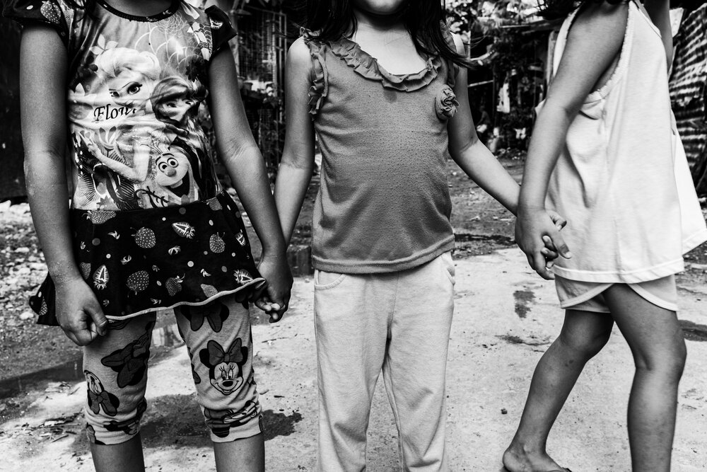  Tiffany (right) holds hands with her playmates outside their house in Pinagbuhatan, Pasig on March 21, 2021. ‘I don’t want her to experience discrimination. I want to introduce her to the community we belong to,’ Mace said. She met other mothers and