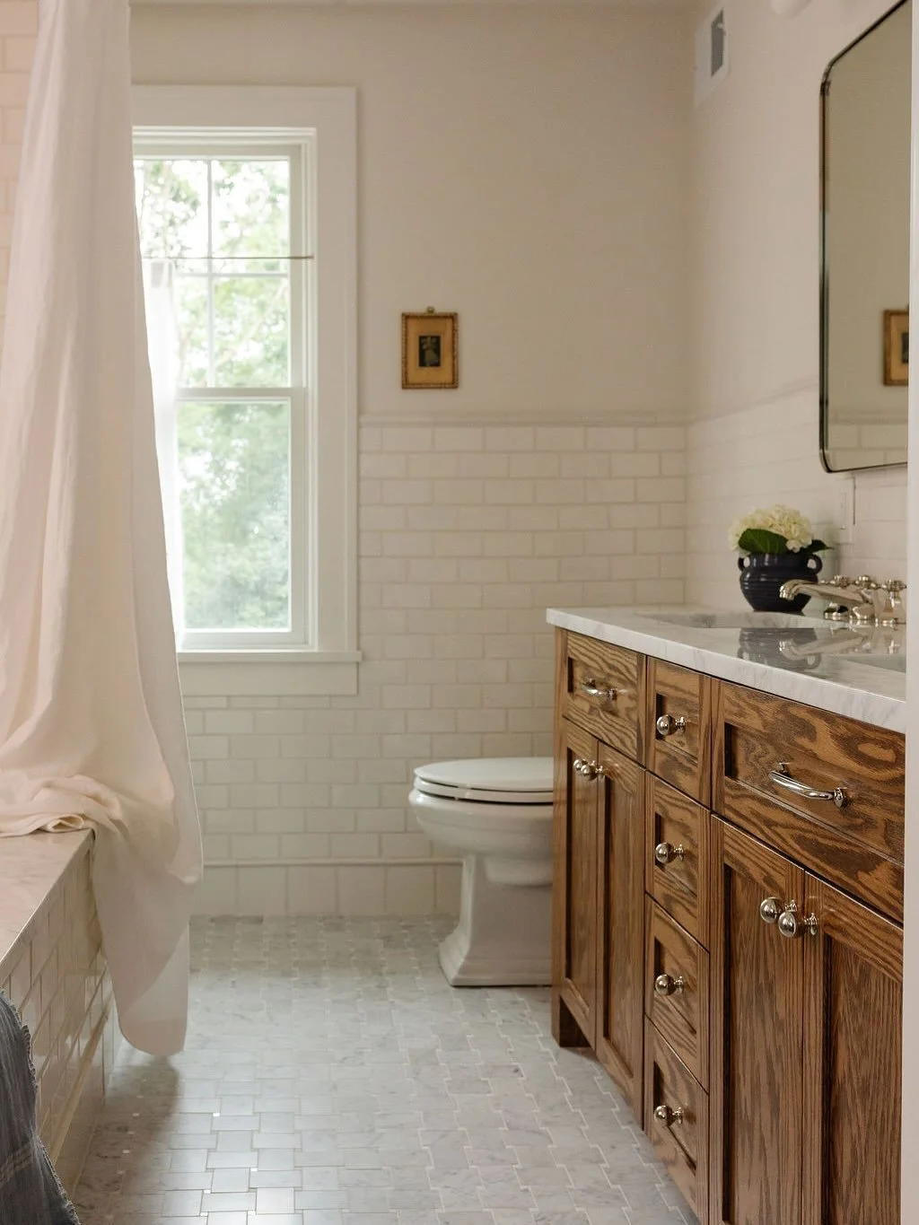 Upstairs, the primary suite underwent a thoughtful reconfiguration. By borrowing space from the large bedroom, flipping the locations of the existing closet and bathroom, we were able to enlarge both spaces. The new bath features a wide oak double va
