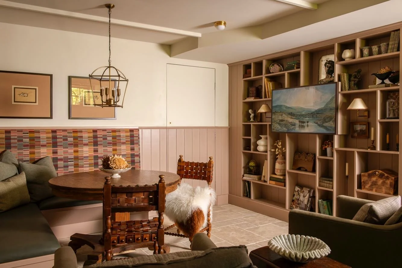 The new lower-level layout creates distinct but connected zones including this game area with custom banquette, and open shelving that creates an interesting display for art and collections.

Notice the inconspicuous jib door that leads to the utilit