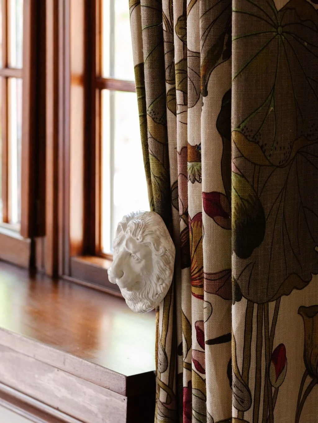 A repeated motif throughout this room is the lion, so we incorporated lion tiebacks for the drapery panels as a tribute to the existing lions featured in the plaster moldings and on the fireplace.

It&rsquo;s details like these &mdash; the ones alrea