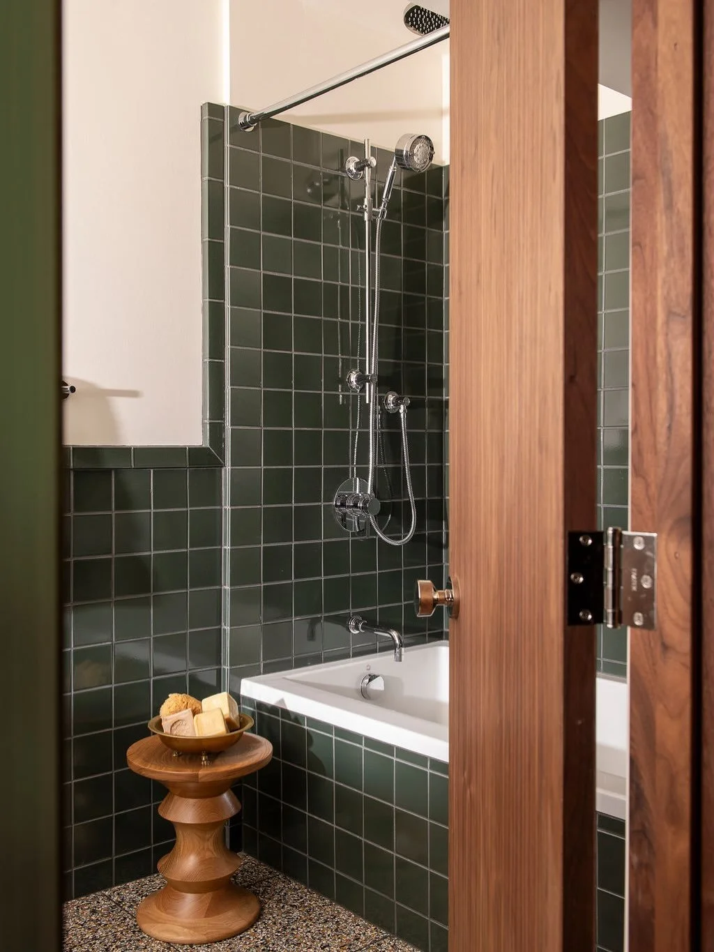 The lower level bathroom was redesigned to maximize both luxury and functionality within the existing footprint.  Beautiful tile installations, including terrazzo flooring, bring texture and personality to the spaces, while walnut storage solutions p