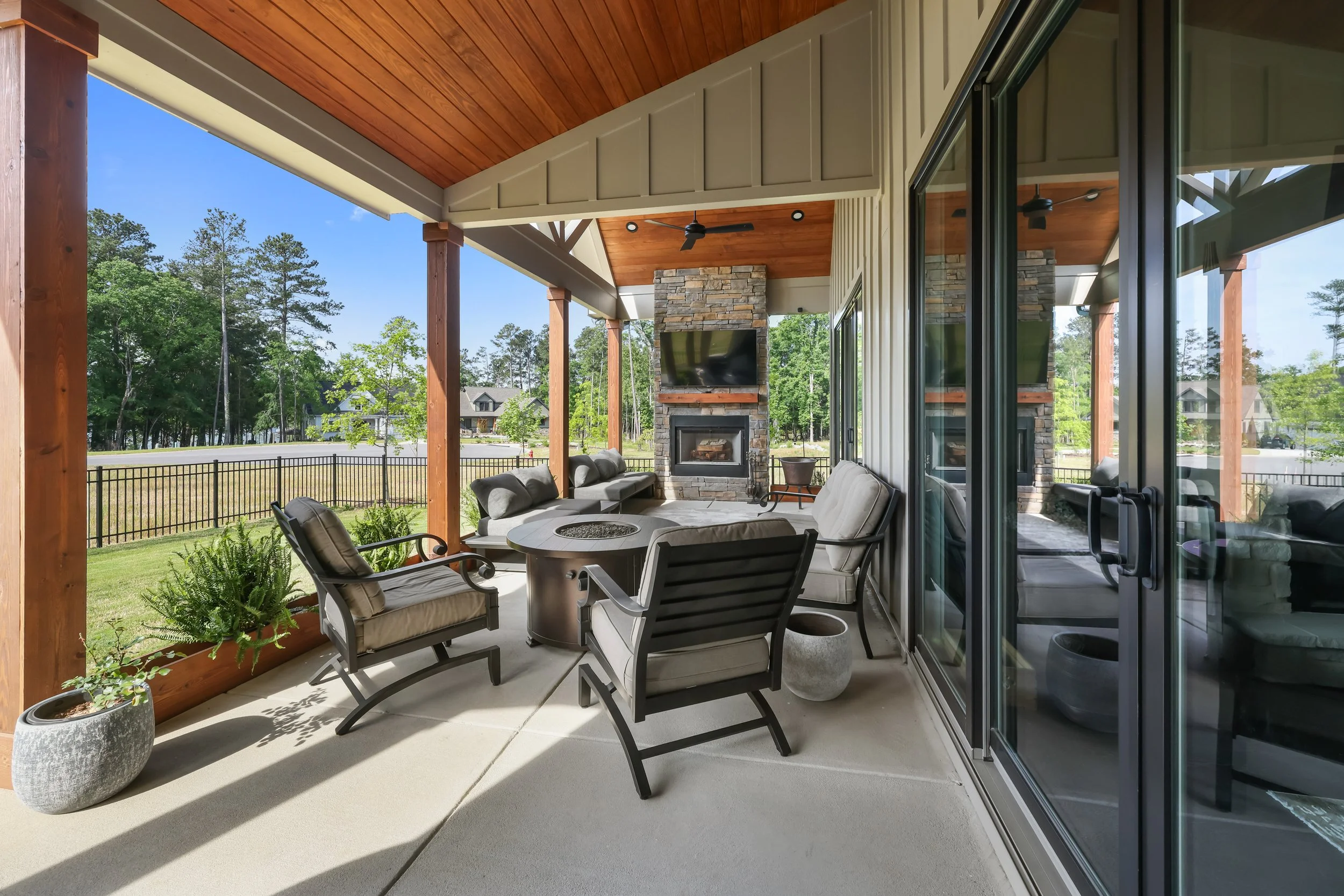 Vaulted covered porch with stacked stone accents and a gas-lit wood-burning fireplace at 615 Misty Banks Drive