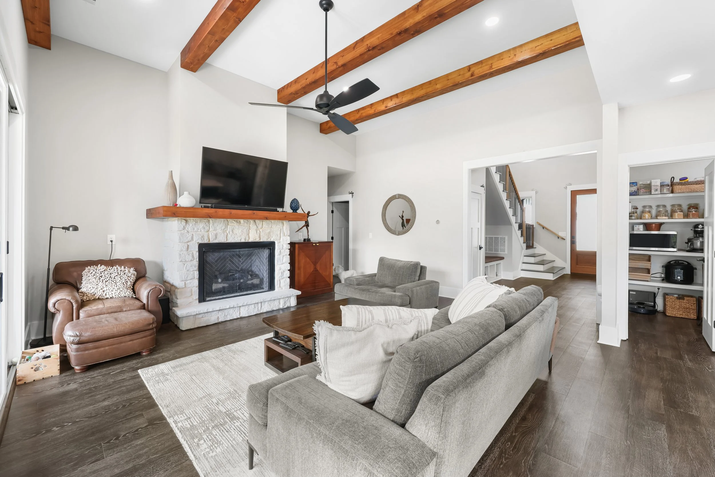 Great room with beam ceiling, gas fireplace, and glass sliders to the covered porch