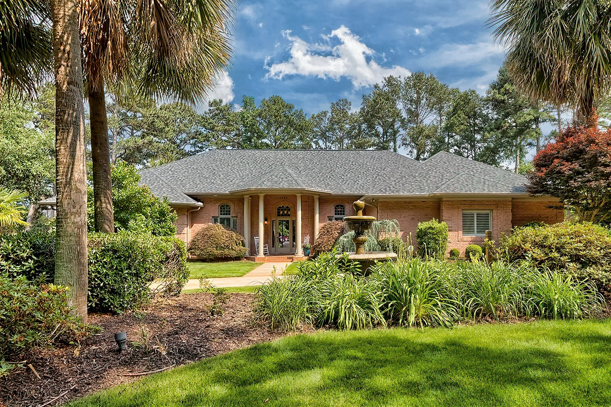 Luxury brick home exterior with fountain and landscaping in Spence Plantation on Lake Murray near Lexington SC