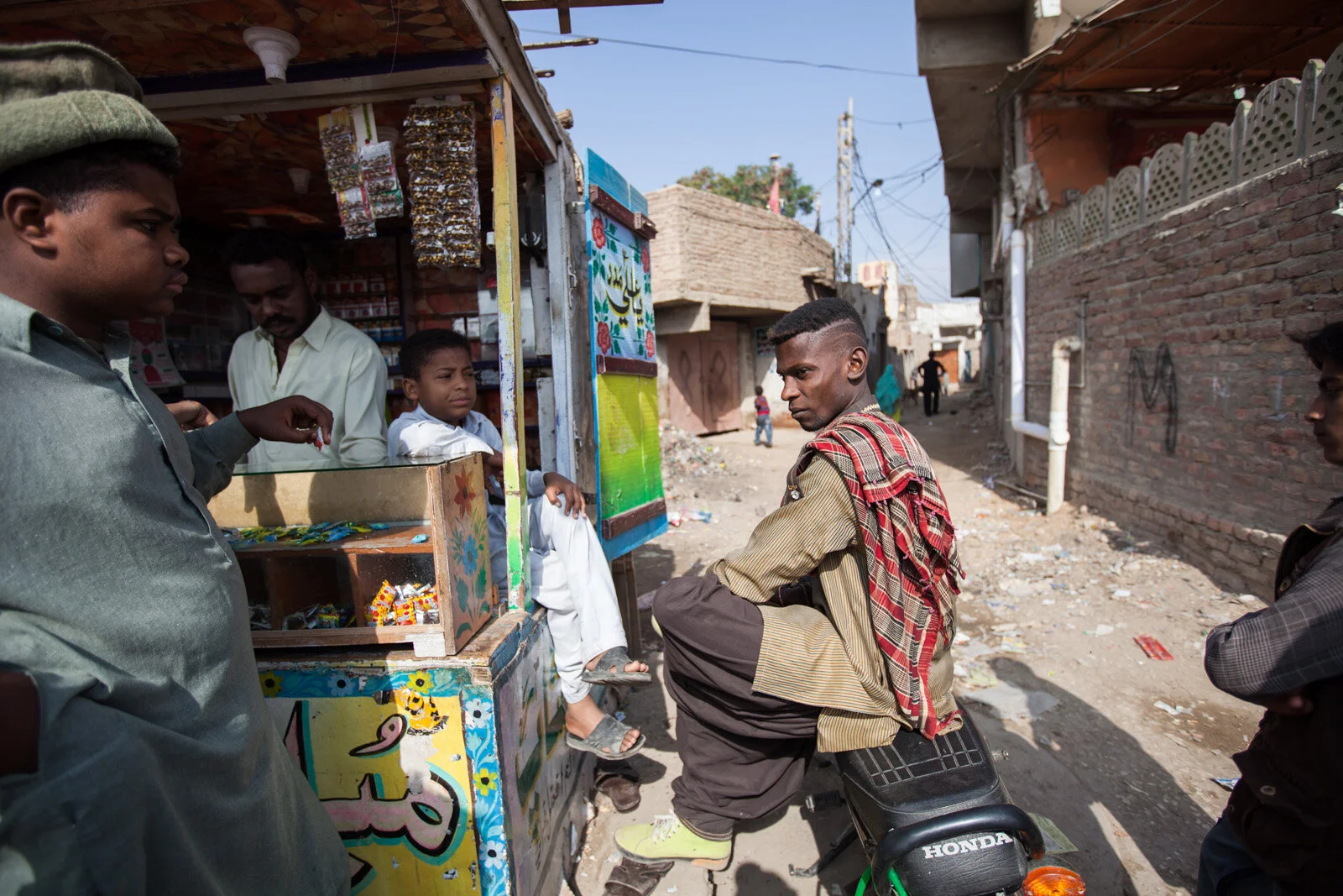 A group of Sheedi hangout at a small shop in the early morning in a suburb of Hyderabad, Pakistan.