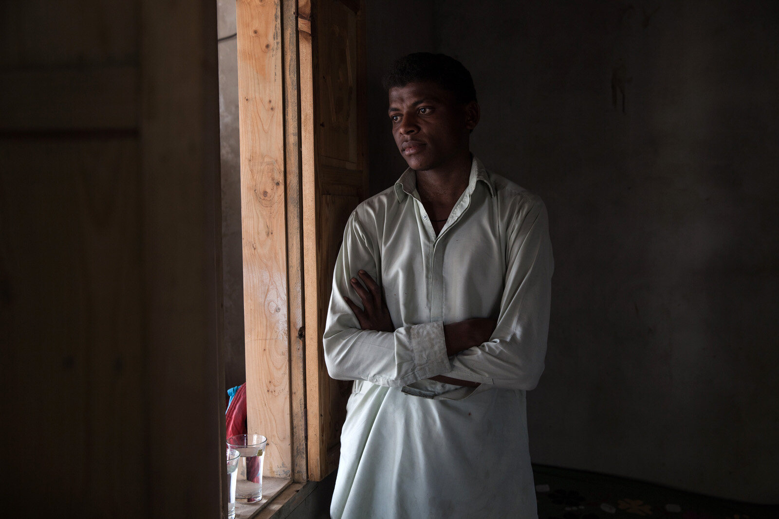 A sheedi man stands in the window of his home in a small village close to the Indian border.