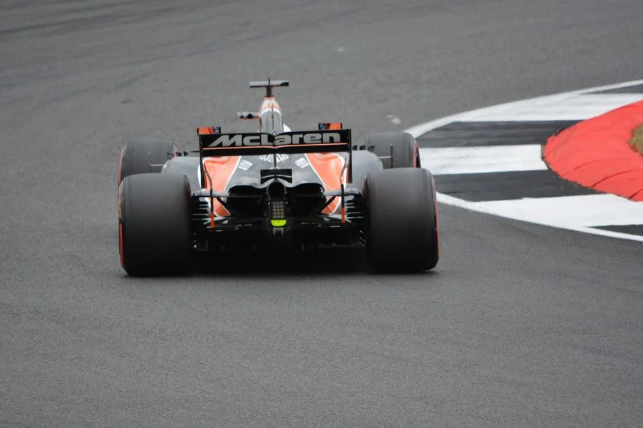 A Formula 1 car in the middle of a corner and ready to get the power down. Photo by Tim Carey on Unsplash