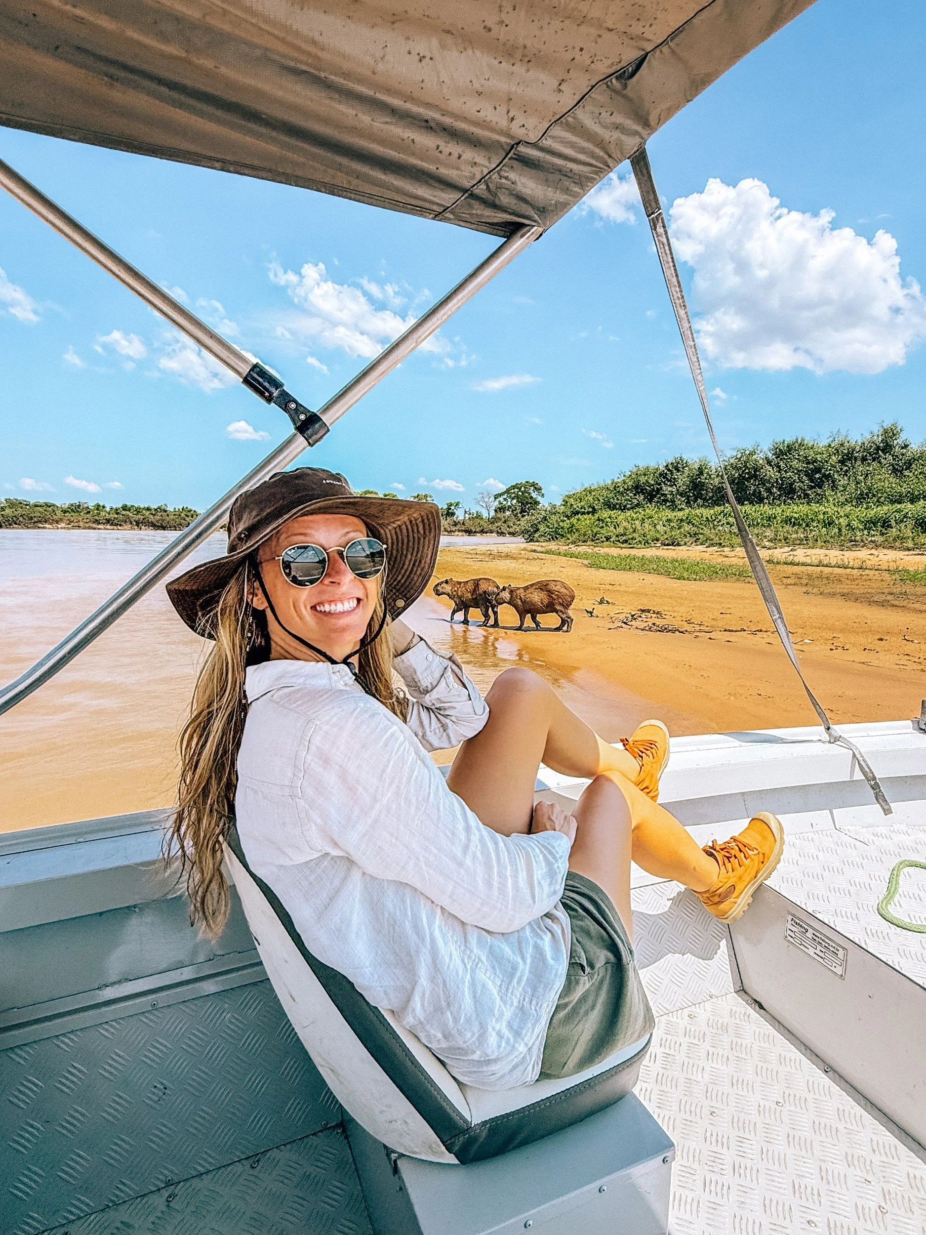 Kellie Paxian on a boat safari with capybaras on the riverbank in the Pantanal, Brazil