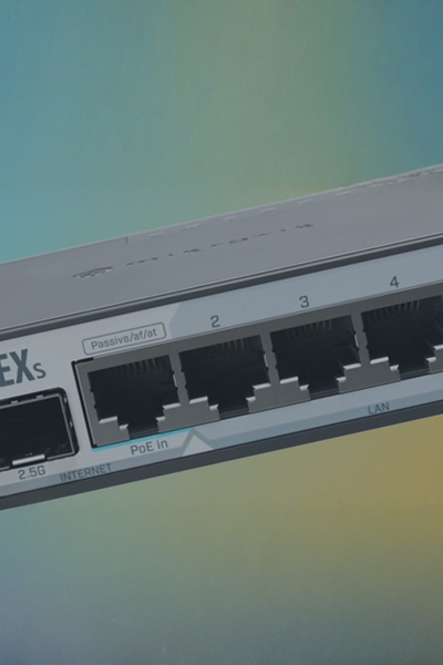 Close-up of a MikroTik network router with Ethernet ports.