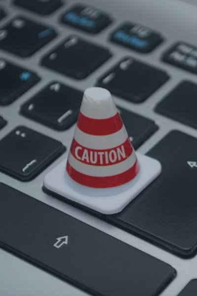 A small caution pylon on a keyboard representing BreachForums Database Breach.