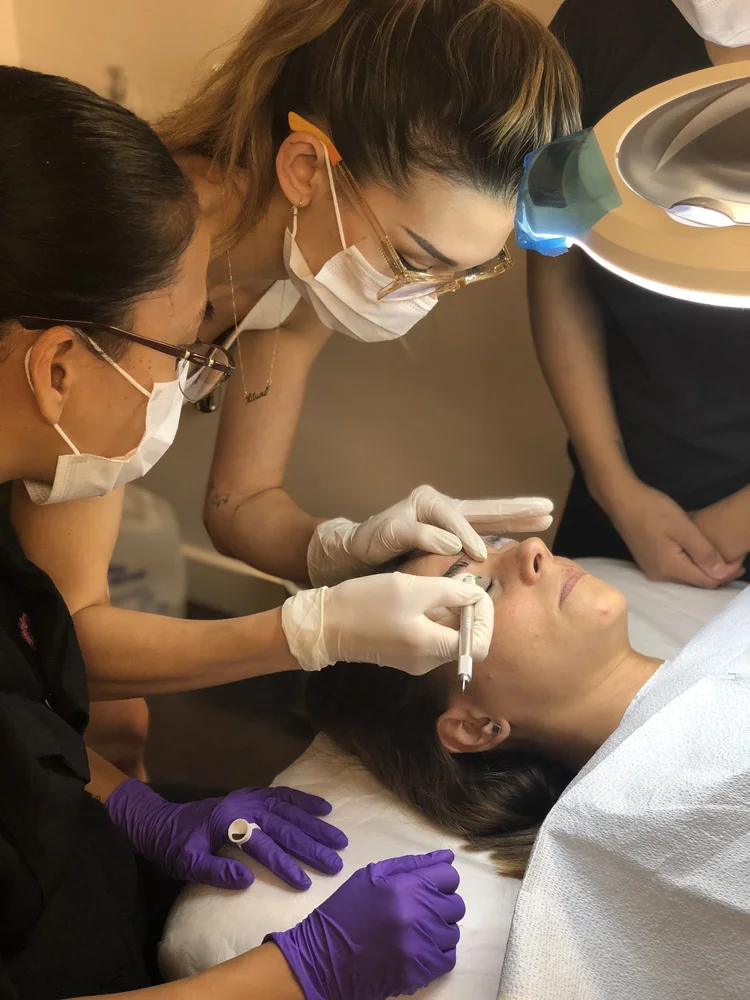 Renée demonstrating permanent makeup technique during training