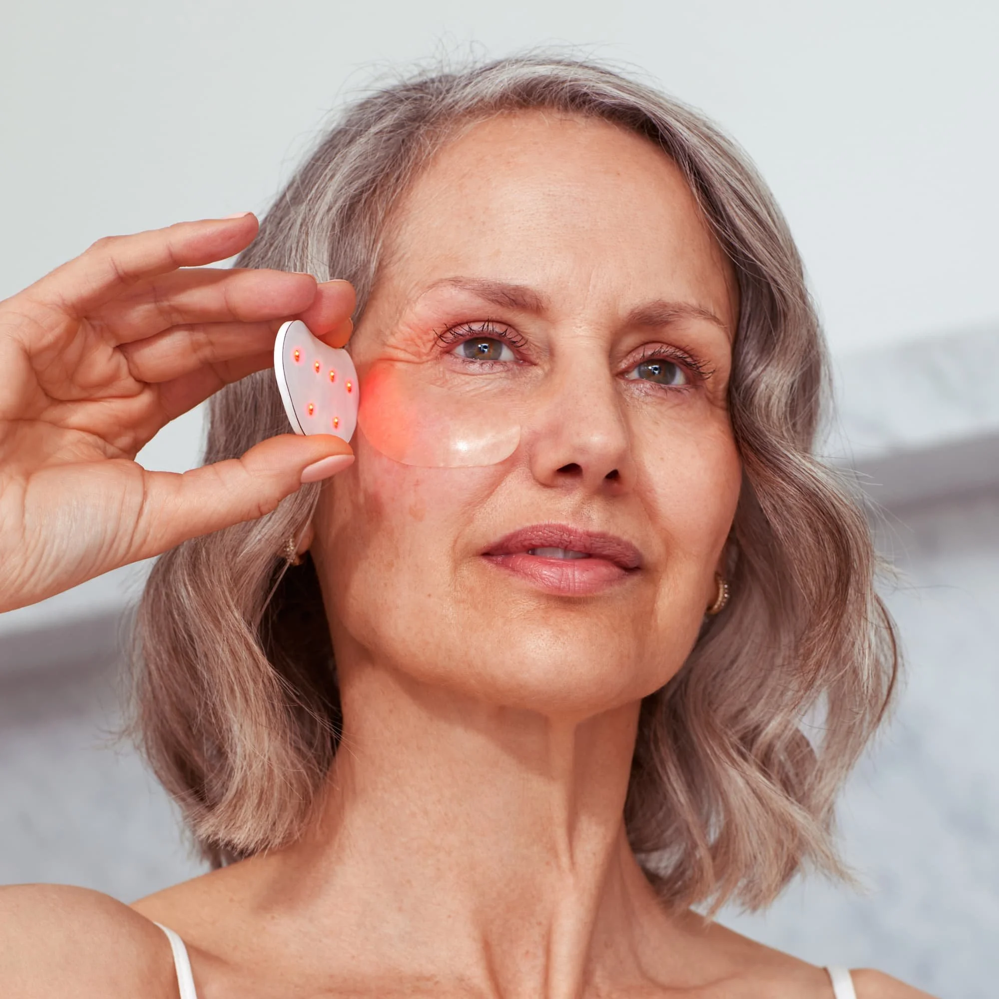 woman applying mini eye brightener on eye