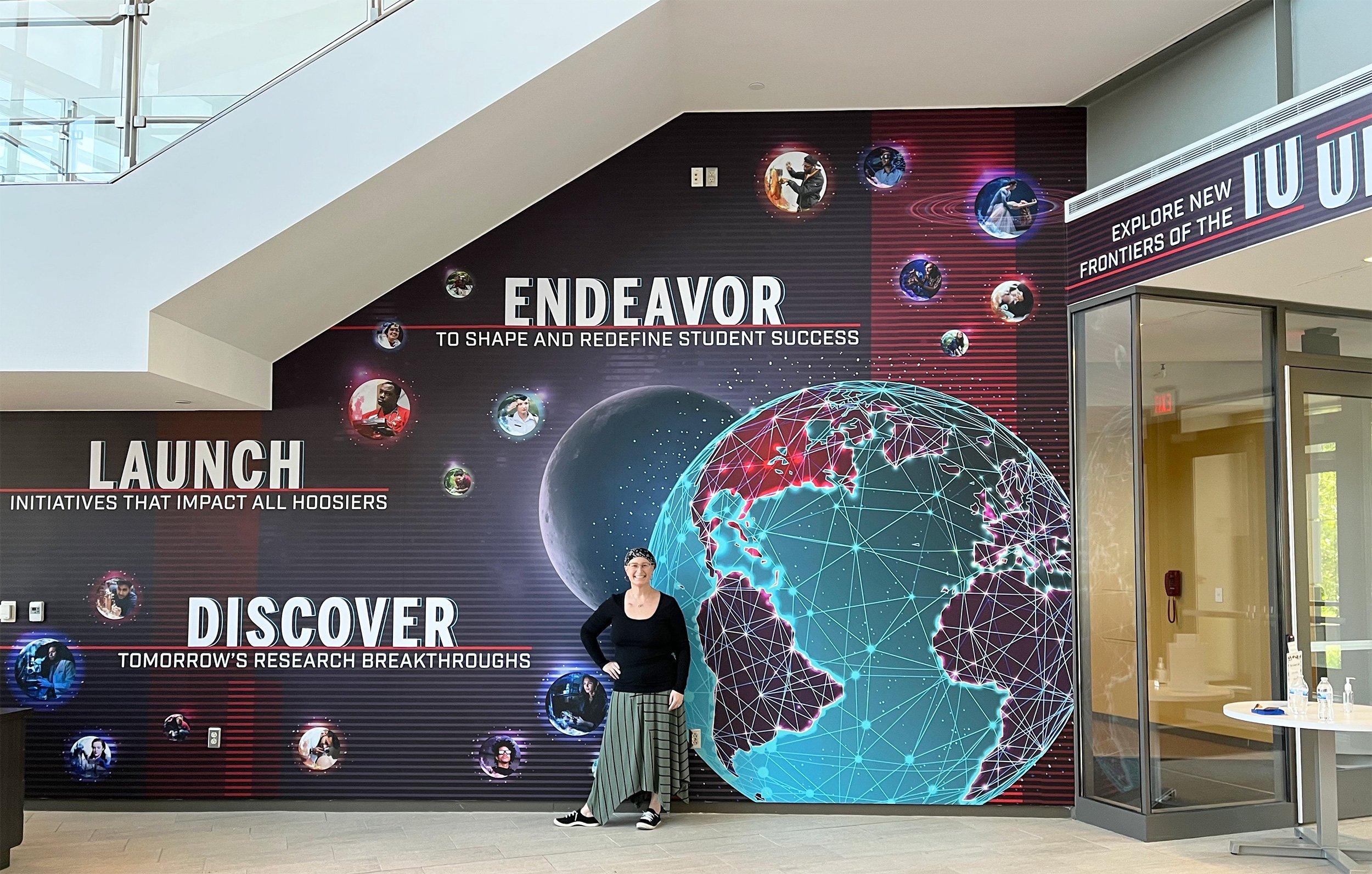 Maria Morris standing in front of IU's CIB lobby mural