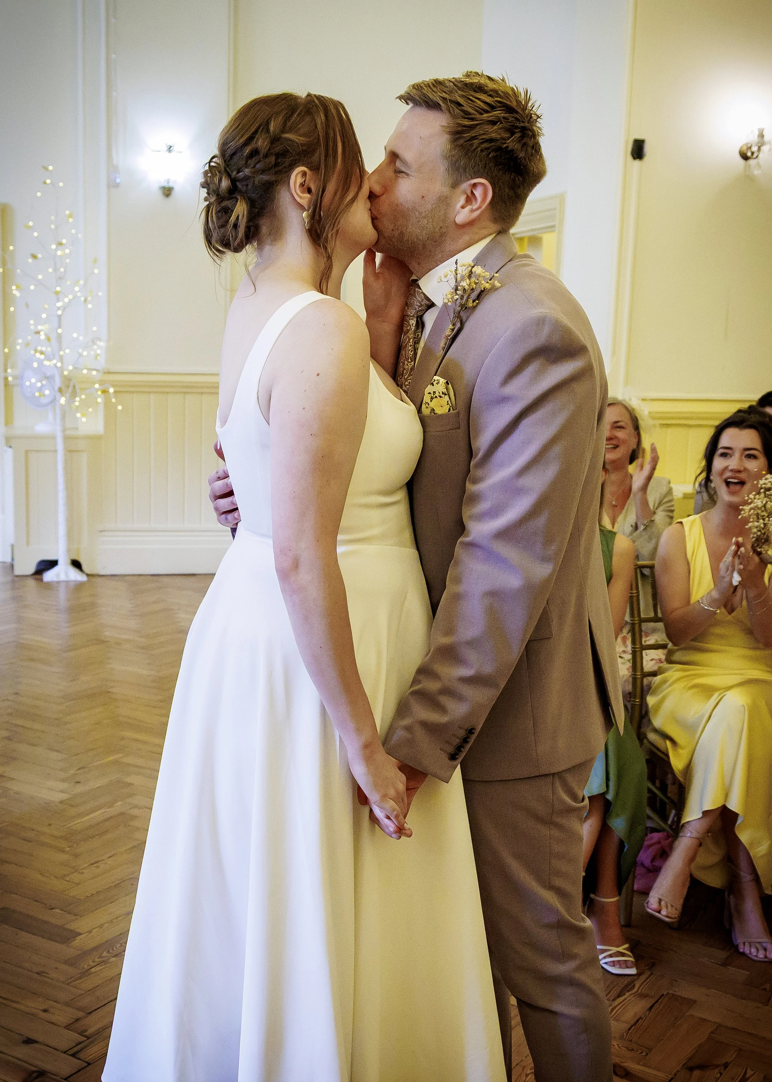Exchanging a kiss in the light-filled Regency Room, Brighton East Sussex
