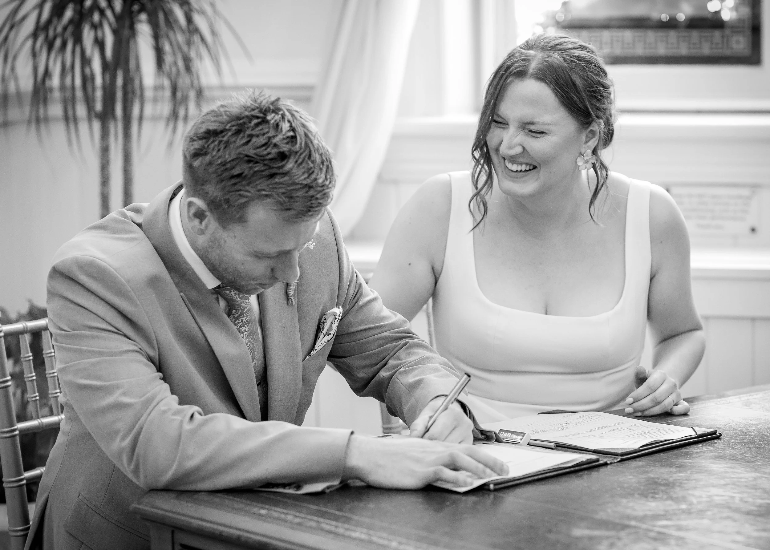 Laughter when signing the register during Emotional wedding ceremony in the Regency Room at Brighton Town Hall - East Sussex Wedding Photography