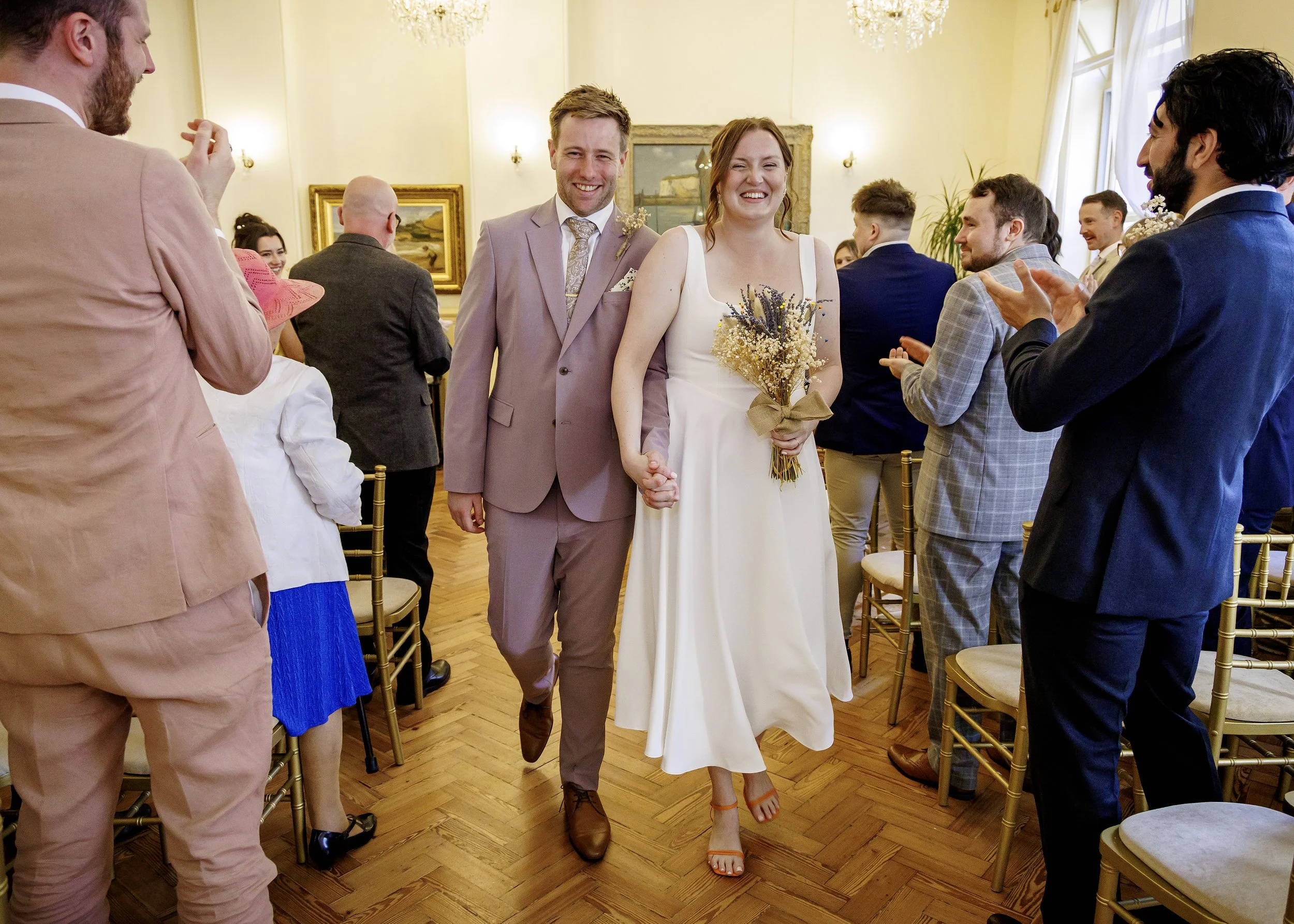 The bride and groom leave the Regency room at Brighton Town Hall and the end of the wedding