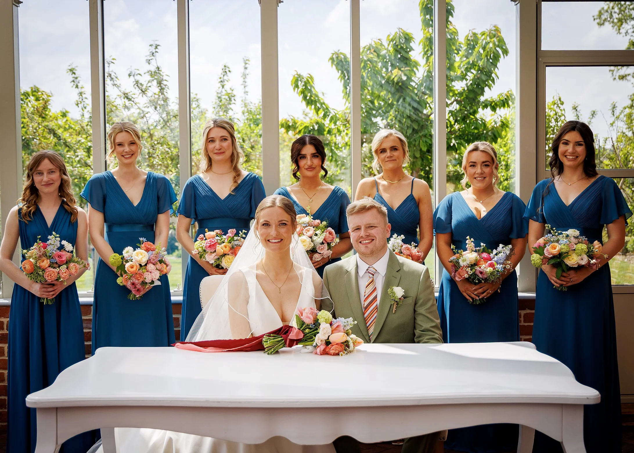 Bride and groom signing the register inside the Glasshouse at Syrencot in Wiltshire - Relaxed, Natural Wedding Photography