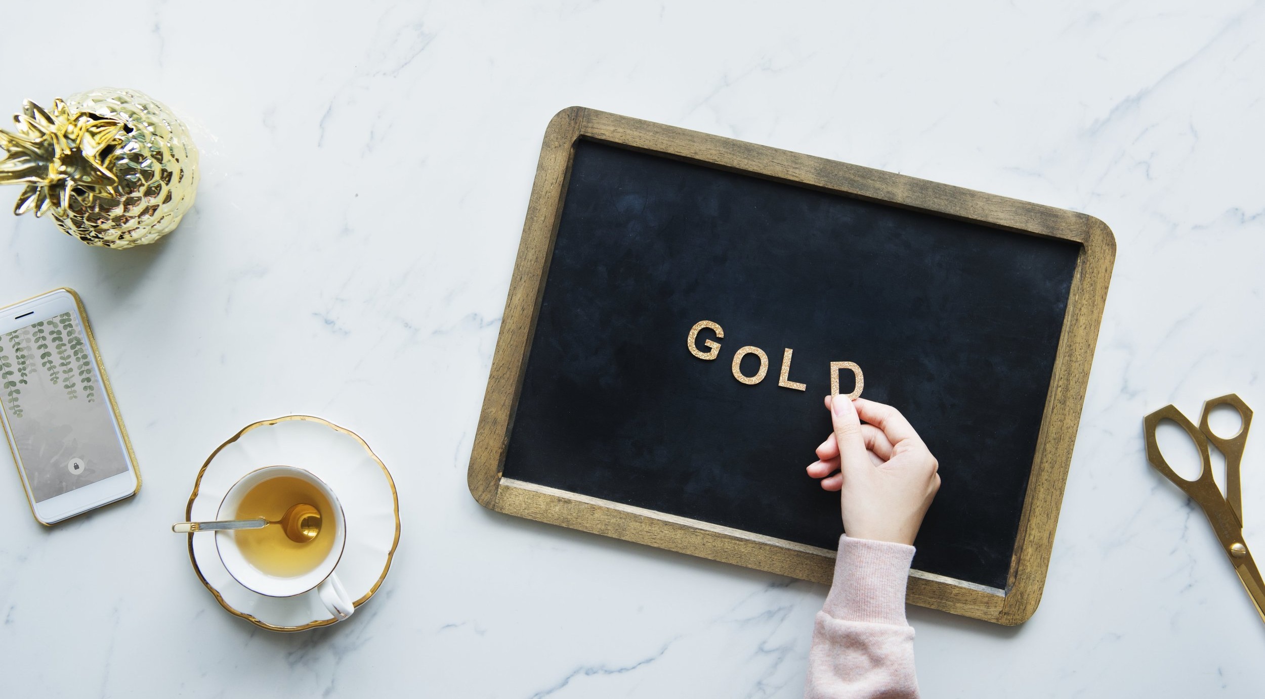 flatlay-of-a-model-spelling-gold-on-a-blackboard.jpg