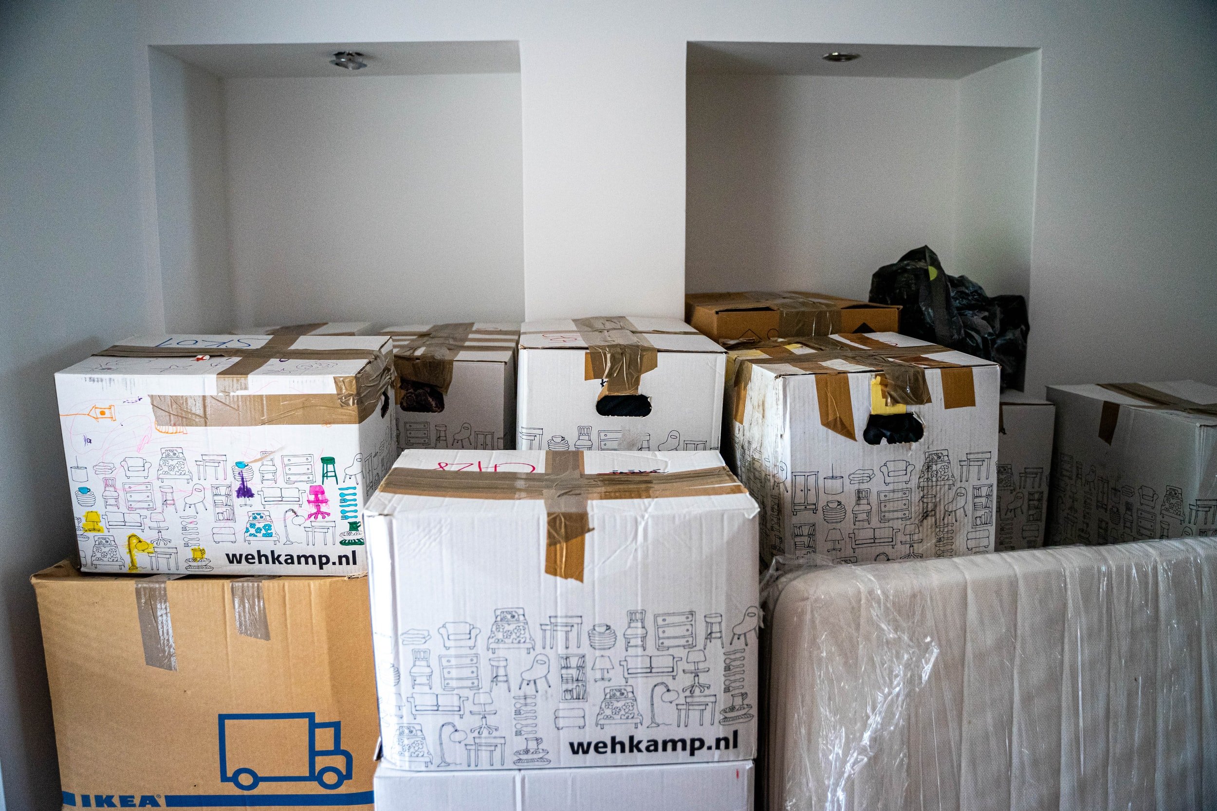 A stack of battered moving boxes in a white room.
