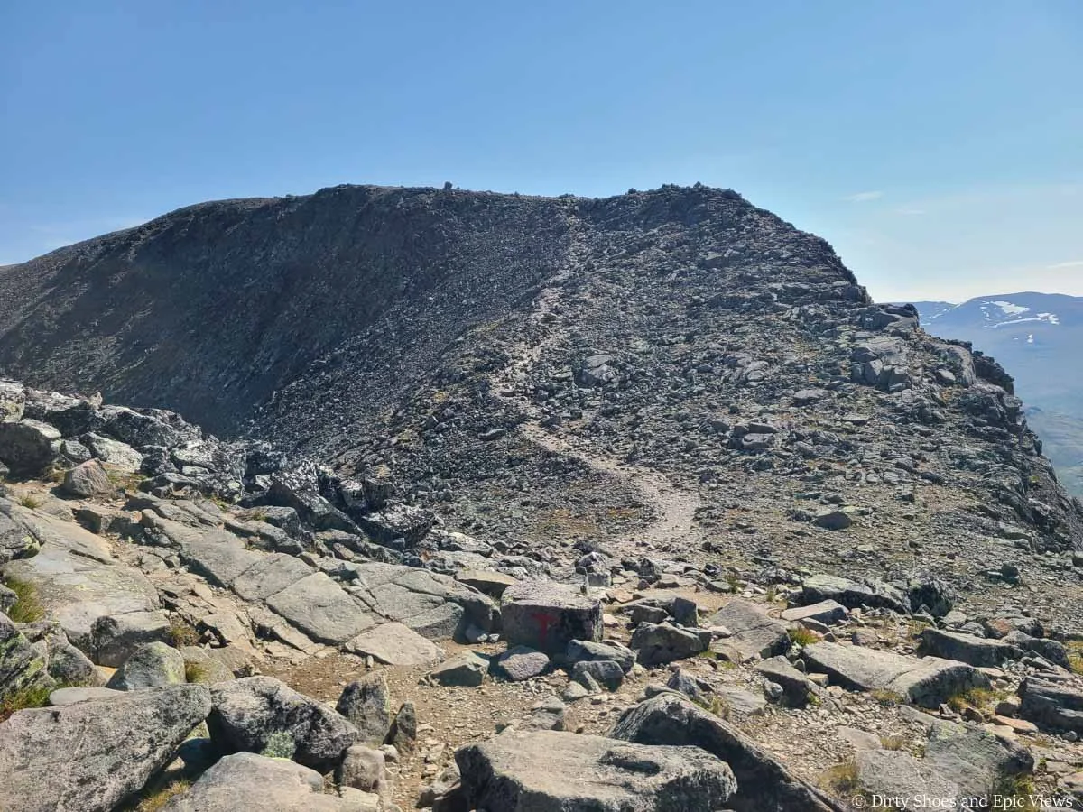 A herd path ascends a rocky ridge along the Besseggen Ridge trail