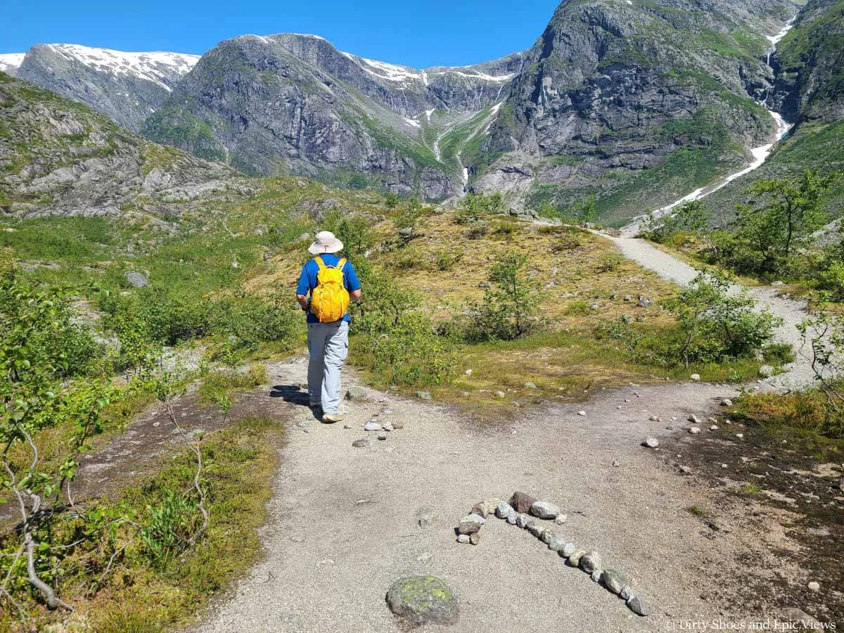 A hiker takes the left path of a fork in the trail on the way to Austerdalsbreen in Norway
