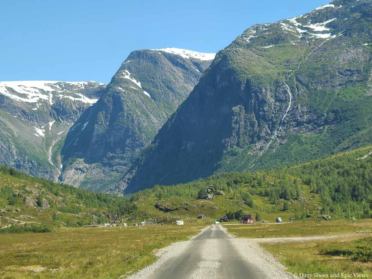Mountains tower over a dirt road on the way to Austerdalsbreen in Norway