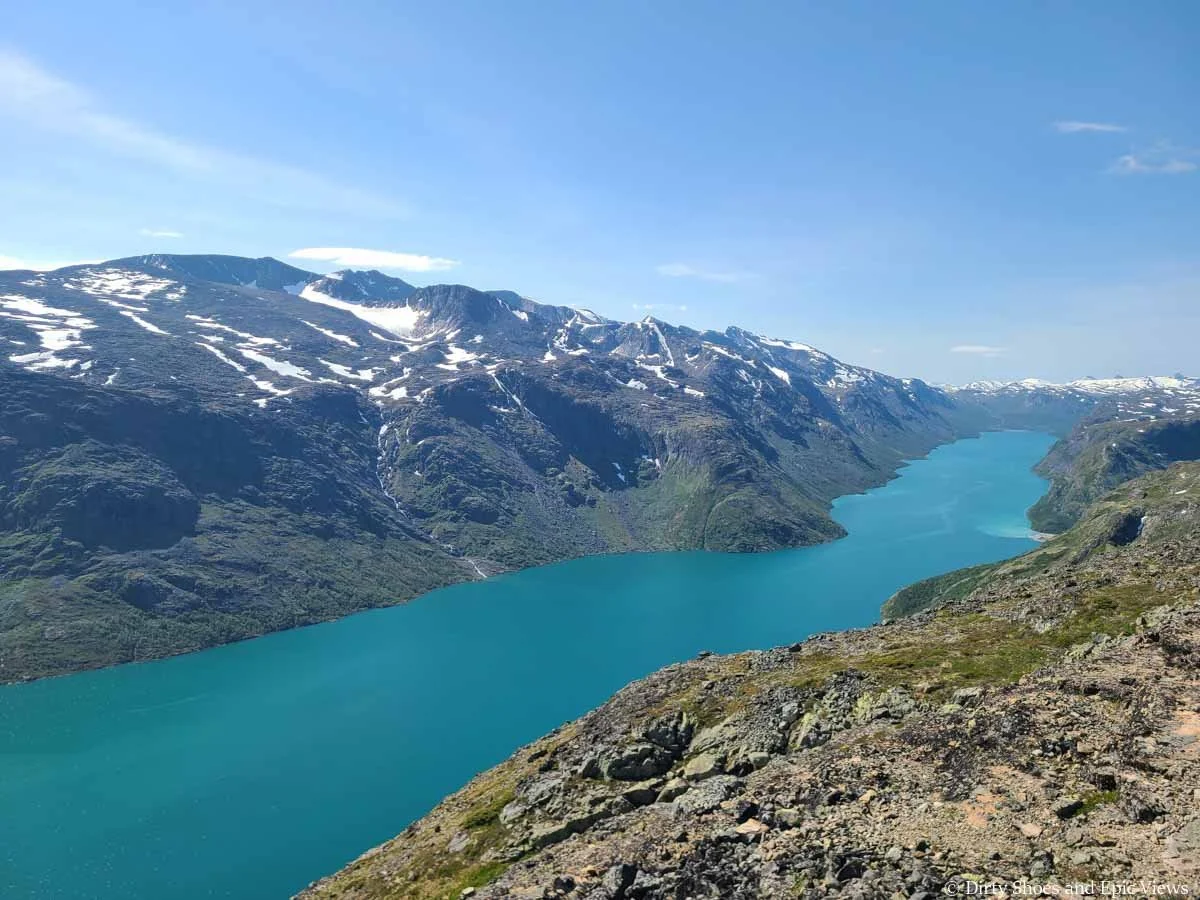 Mountains rise above a long turquoise lake along the Besseggen Ridge trail in Norway