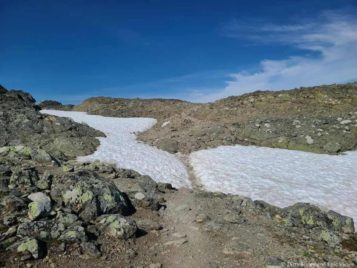 A small snow patch sits across the Besseggen Ridge Trail