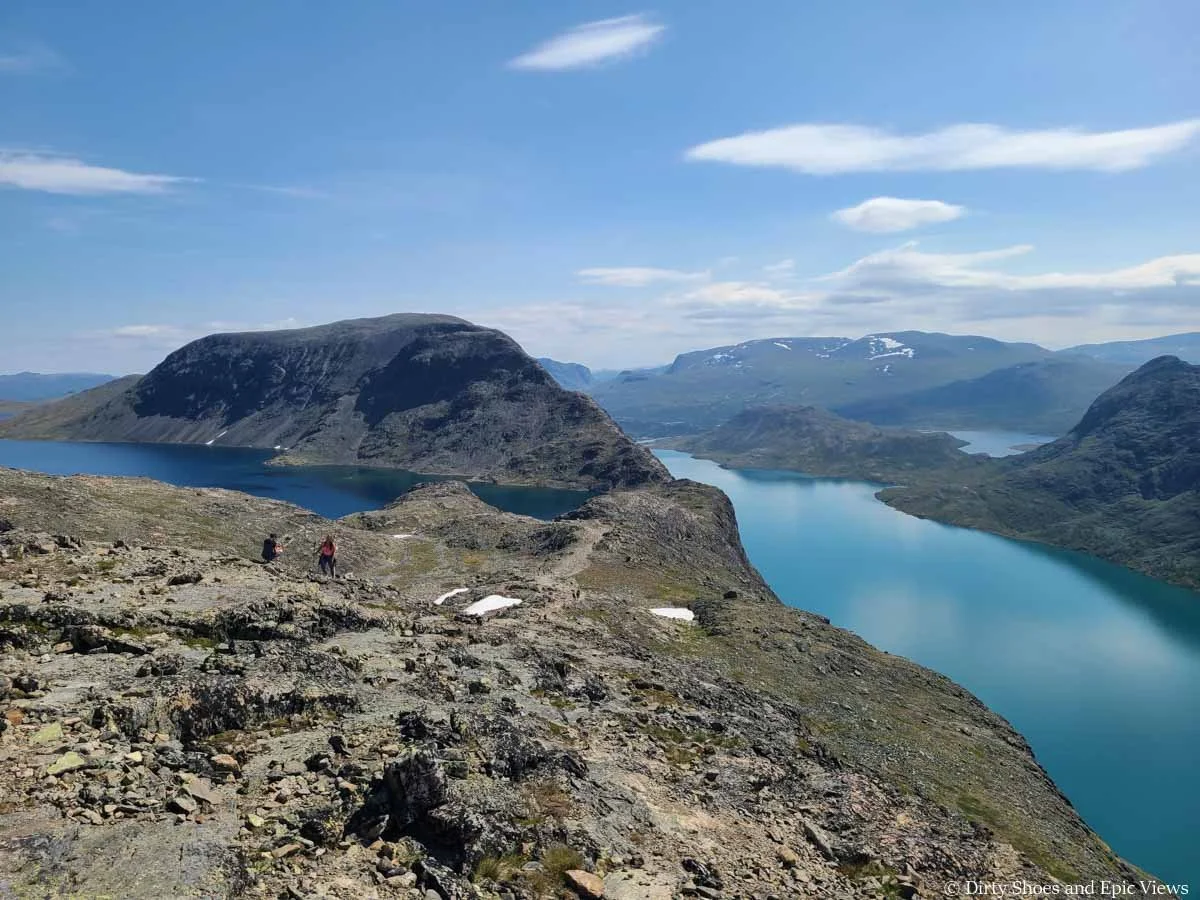 A rocky ridge descends between two lakes with mountain views on the Besseggen Ridge hike in Norway