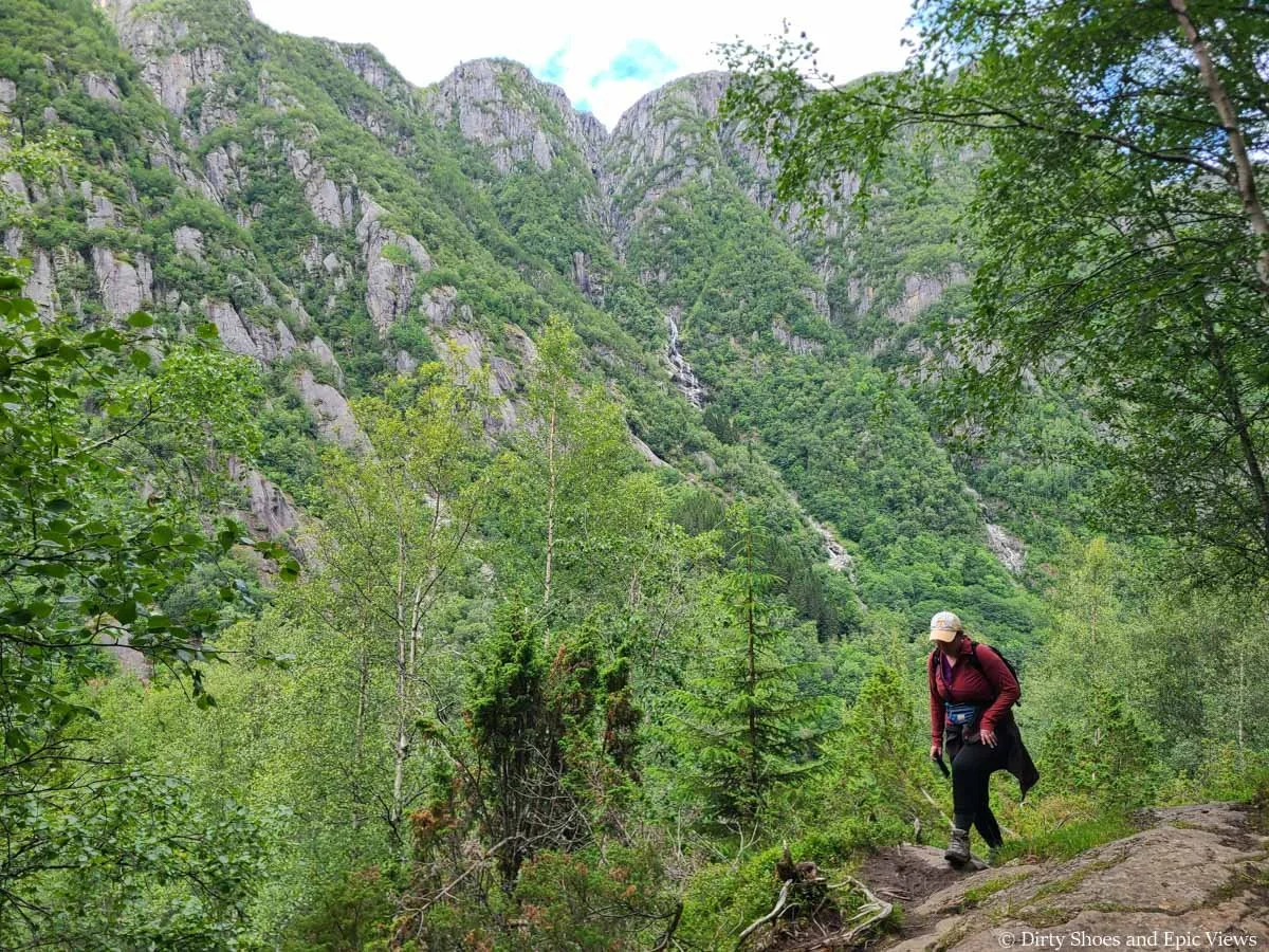A hiker walks along the Reinanuten trail in Norway with mountain views in the background