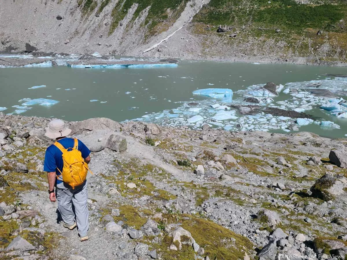 A hiker descends slick and rocky herdpaths down to a glacier lake at Austerdalsbreen
